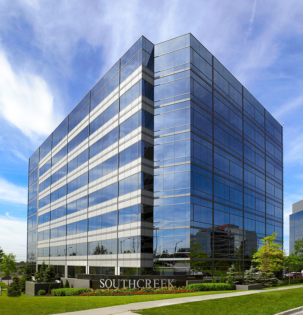 Exterior of Southcreek corporate building on sunny day with clouds and polished landscaping